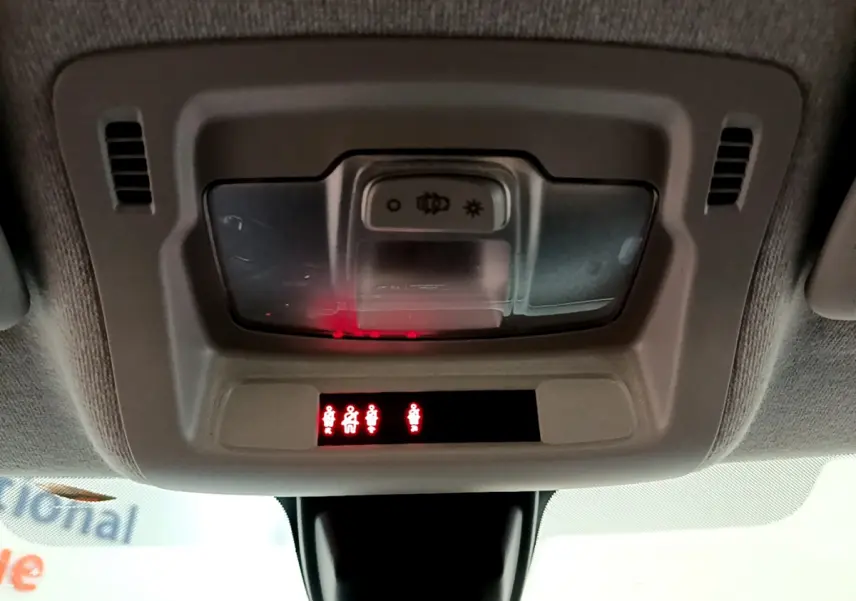 Vue du plafonnier intérieur de la Citroën C3 blanc, avec éclairage et indicateurs de ceinture allumés.