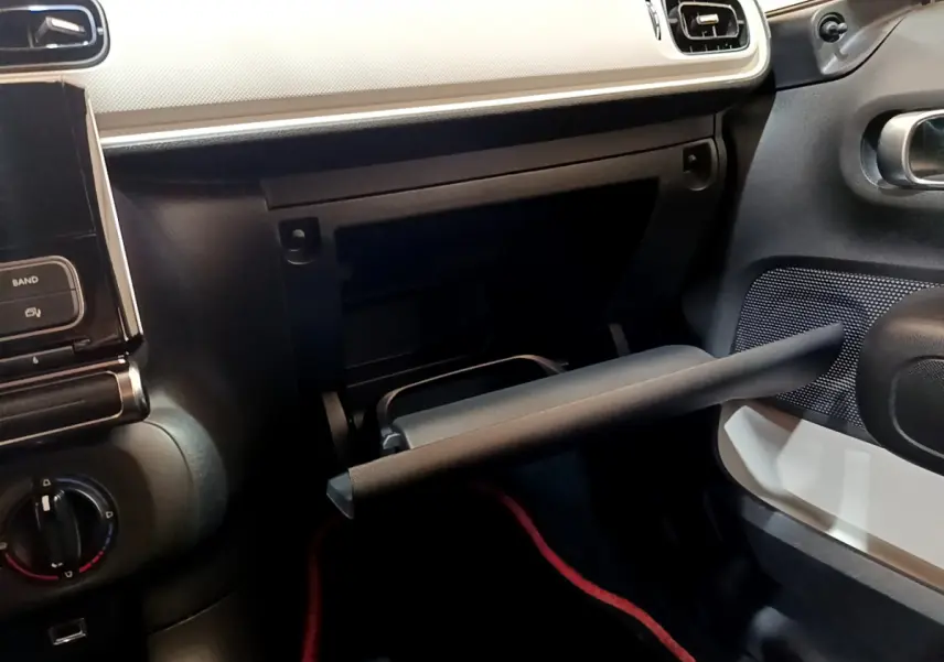 Intérieur de la Citroën C3 PureTech 68 BVM Live 2018, vue côté passager avec boîte à gants ouverte et tableau de bord noir et blanc.