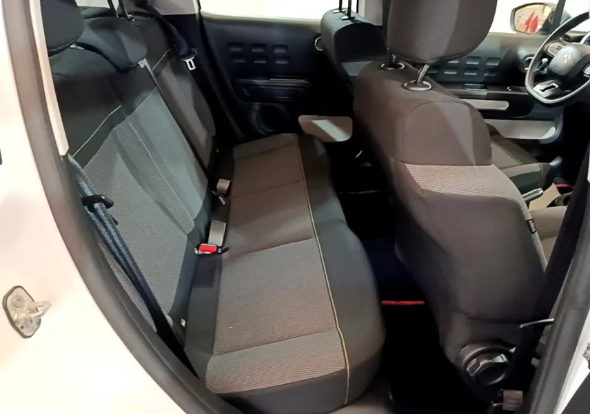 Vue intérieure côté gauche de la banquette arrière et sièges avant noirs d'une Citroën C3 blanche 2018.