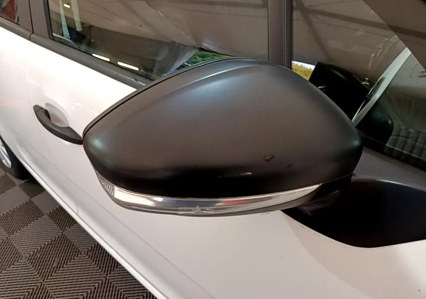 Gros plan sur le rétroviseur noir avec clignotant intégré côté gauche d'une Citroën C3 blanche de 2018.