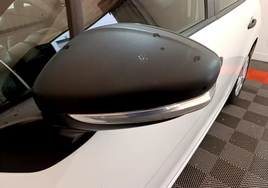 Gros plan sur le rétroviseur noir côté gauche de la Citroën C3 blanche PureTech 68 BVM Live de 2018.