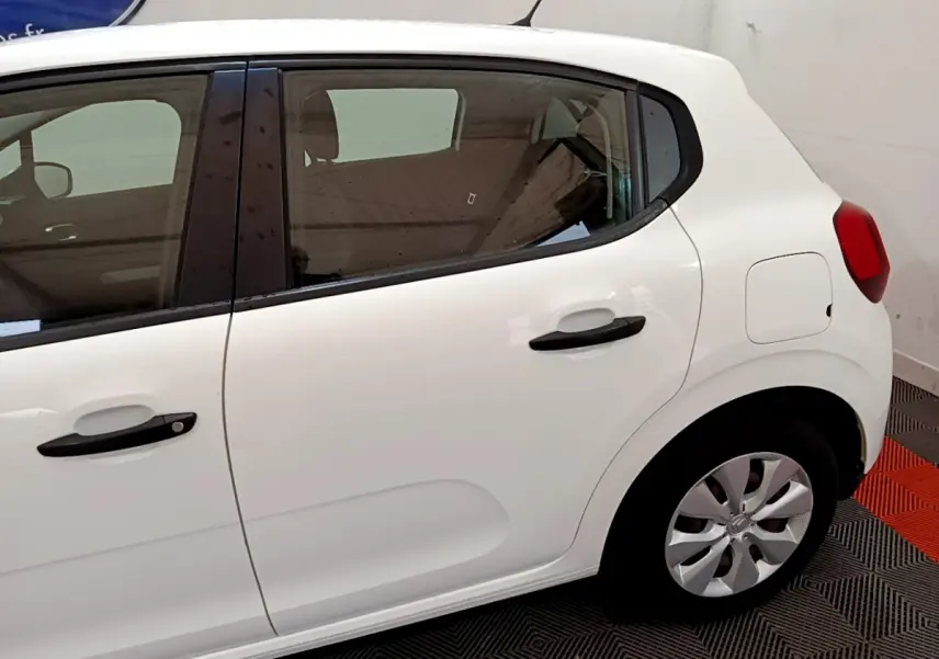 Vue latérale droite d'une Citroën C3 blanche de 2018 avec poignées noires et jantes compactes visibles.