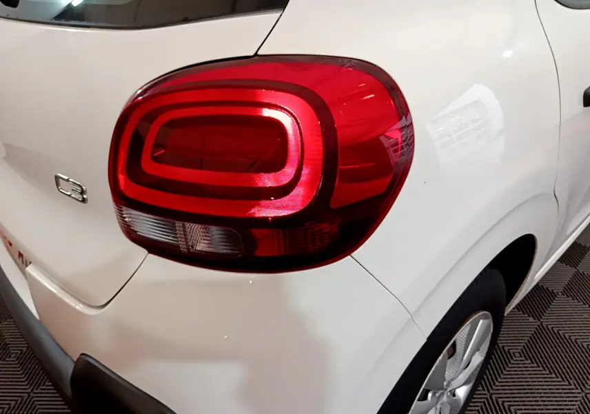 Gros plan sur le feu arrière droit rouge d'une Citroën C3 blanche de 2018, avec logo et partie latérale visible.