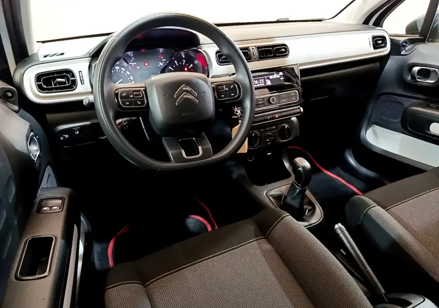 Intérieur avant de la Citroën C3 blanche 2018, vue côté conducteur avec tableau de bord et boîte manuelle visibles.