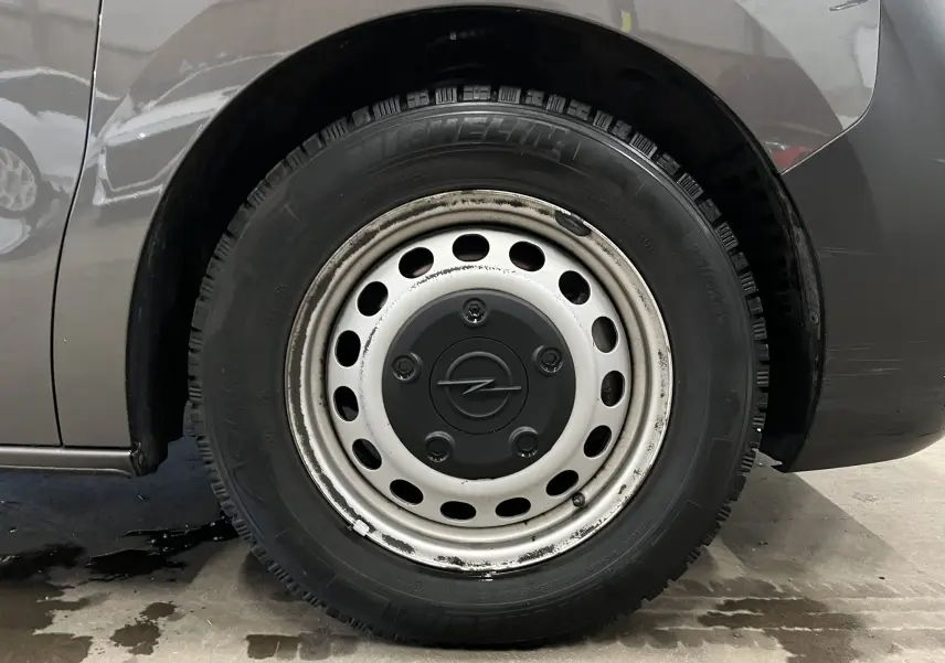 Gros plan sur la roue arrière droite grise d’un Opel Vivaro XL 2023 avec jante acier et logo Opel central.