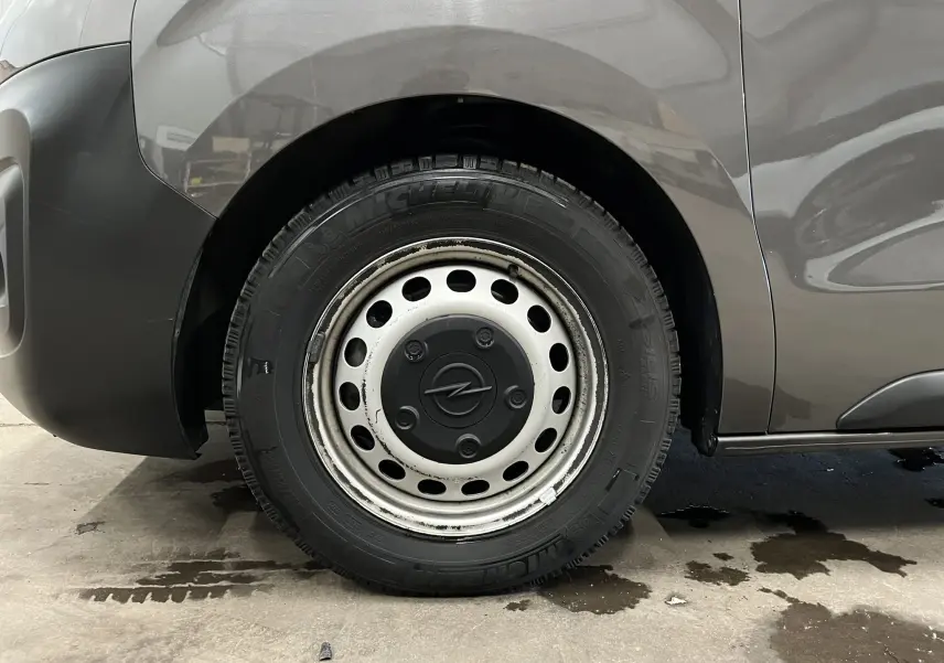 Gros plan sur la roue arrière droite grise d’un Opel Vivaro XL 2023 avec jante acier et logo Opel central.