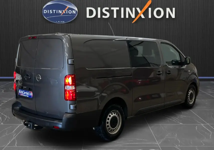 Opel Vivaro cabine approfondie gris, vue 3/4 arrière droit, portes arrière fermées et attelage visible.
