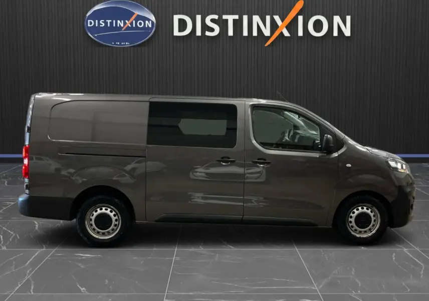 Vue de profil côté droit d’un Opel Vivaro Cabine Approfondie gris 2023 avec vitres teintées et jantes acier.