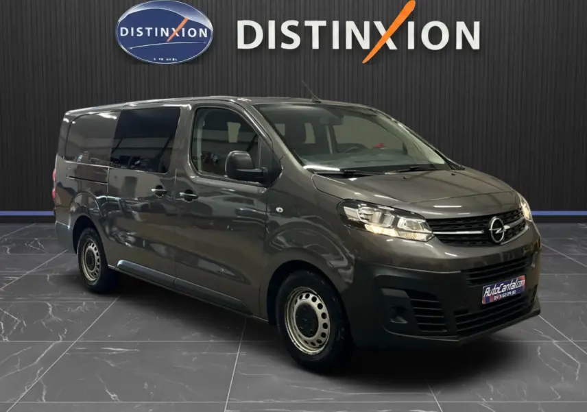 Opel Vivaro cabine approfondie gris 3/4 avant droit, avec vitres teintées et jantes acier noires.