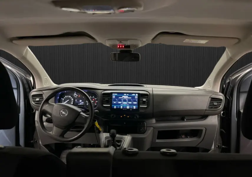 Vue intérieure avant de l’Opel Vivaro XL gris 2023, tableau de bord avec écran tactile et volant à gauche.