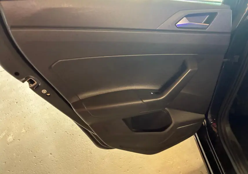 Vue intérieure de la porte arrière gauche noire du Volkswagen Polo 2022 avec poignée intégrée et commande de vitre électrique.