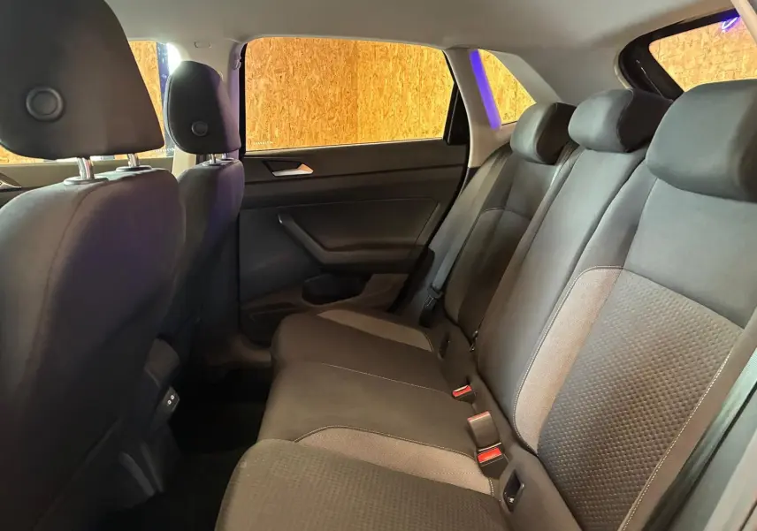 Vue intérieure de la banquette arrière gris noir en tissu de la Volkswagen Polo 2022, côté droit avec appuis-tête et ceintures.