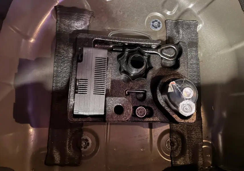 Vue en plongée sur le coffre d’une Volkswagen Polo noire, montrant le rangement d’outils et accessoires intégrés.