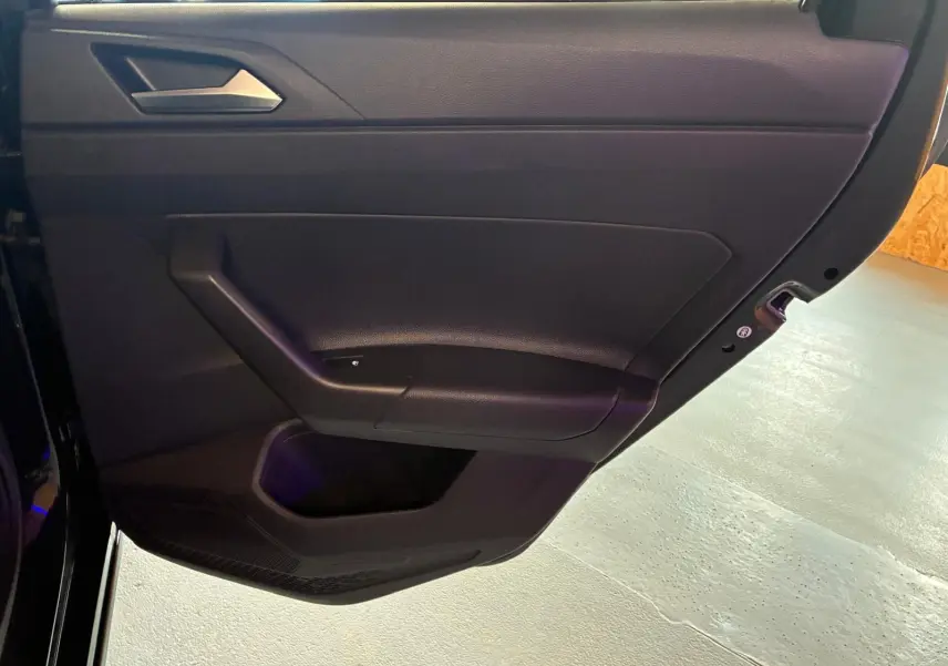 Vue rapprochée de la porte intérieure côté gauche noire de la Volkswagen Polo 1.0 TSI 95 DSG7 Life 2022 avec poignée intégrée.