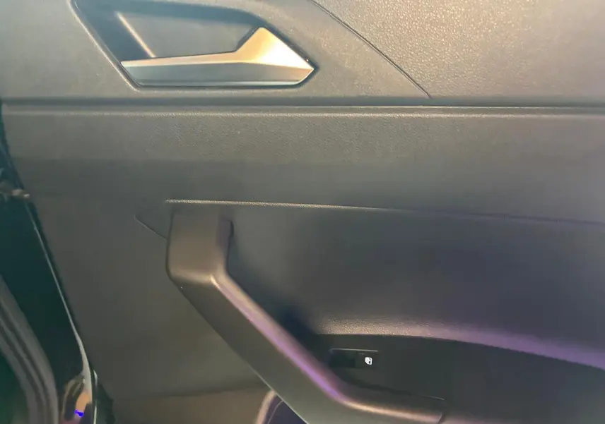 Détail de la porte avant gauche noire d'une Volkswagen Polo 2022 avec poignée et bouton de verrouillage intégré.