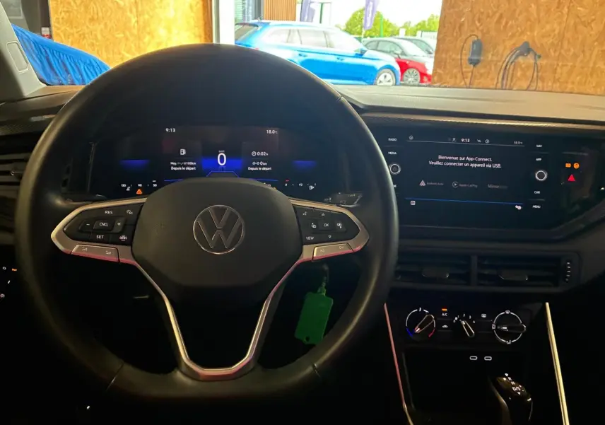 Vue intérieure centrée sur le volant cuir noir et le tableau de bord digital d'une Volkswagen Polo 2022.