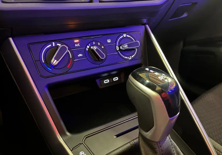 Gros plan intérieur sur la console centrale noire de la Volkswagen Polo 1.0 TSI 95 DSG7 Life avec commandes climatisation et levier de vitesse automatique.
