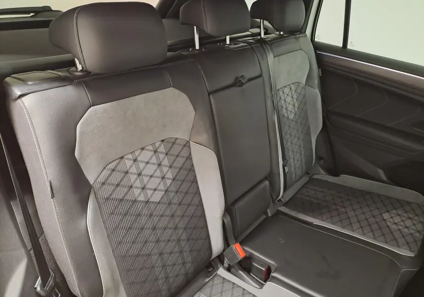 Vue intérieure des sièges arrière en cuir noir et tissu gris à motifs du Volkswagen Tiguan Allspace 2023.