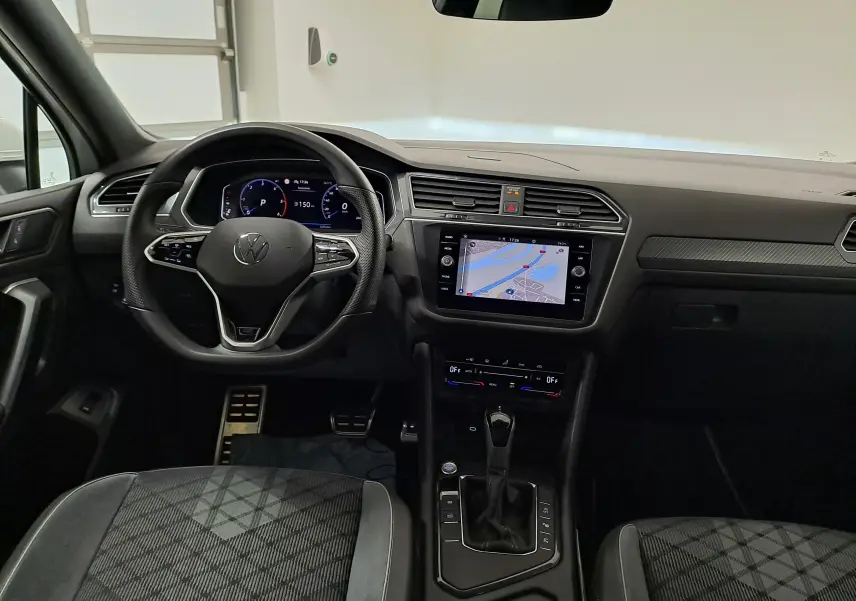 Vue intérieure du tableau de bord du Volkswagen Tiguan Allspace 2023, avec volant multifonction et écran tactile central.