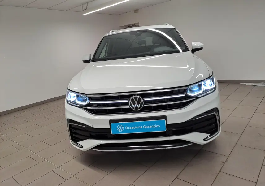 Vue frontale d'un Volkswagen Tiguan Allspace blanc pur 2023 avec phares LED allumés et finition R-Line visible.