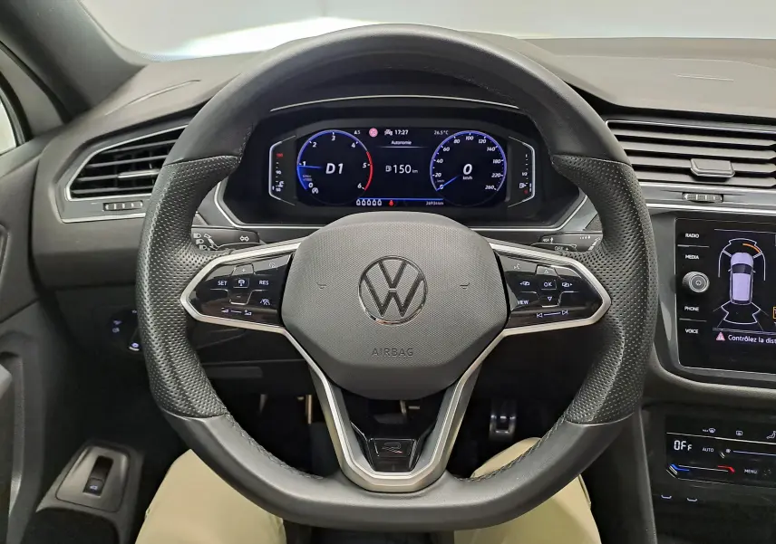 Vue centrée du volant perforé et du tableau de bord numérique du Volkswagen Tiguan Allspace blanc pur 2023, version R-Line.