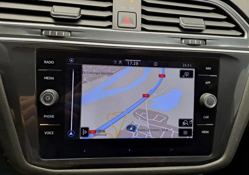 Vue rapprochée de l'écran tactile central du Volkswagen Tiguan Allspace 2023 blanc, affichant la navigation GPS.