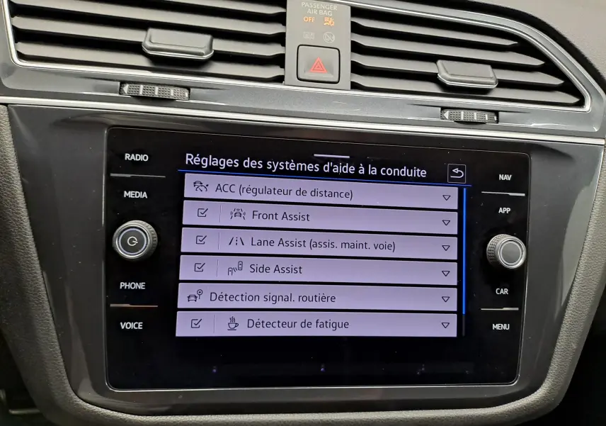 Écran tactile central du Volkswagen Tiguan Allspace 2023 blanc, affichant les réglages des aides à la conduite.