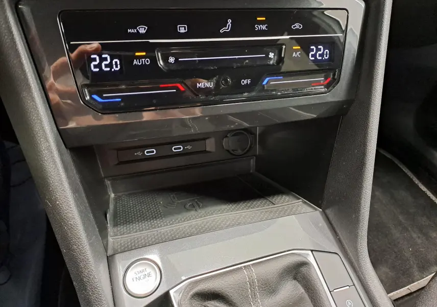 Détail de la console centrale du Volkswagen Tiguan Allspace 2023 blanc, avec commandes climatisation digitales et bouton start engine.