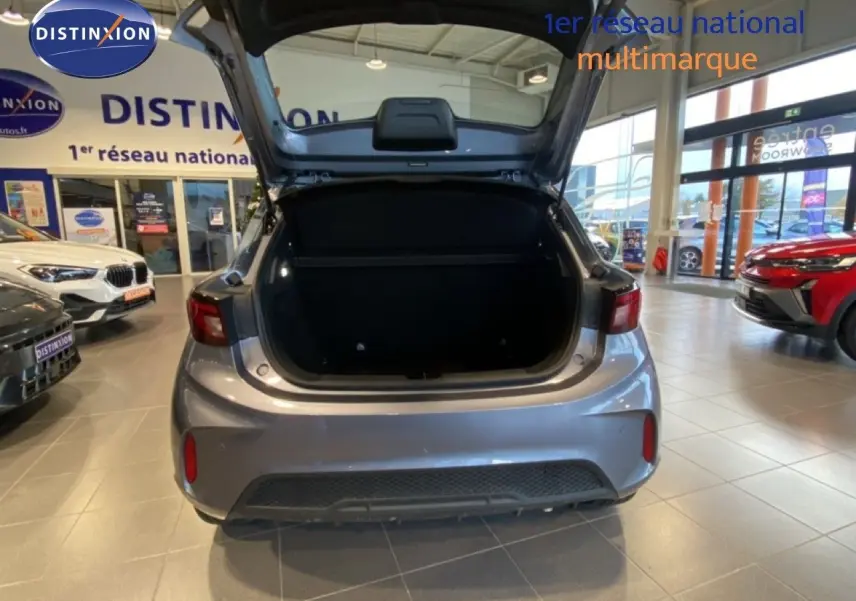 Vue arrière du MG3 1.5 Hybrid 195ch Comfort en gris métallisé Hampstead avec coffre ouvert dans un showroom.
