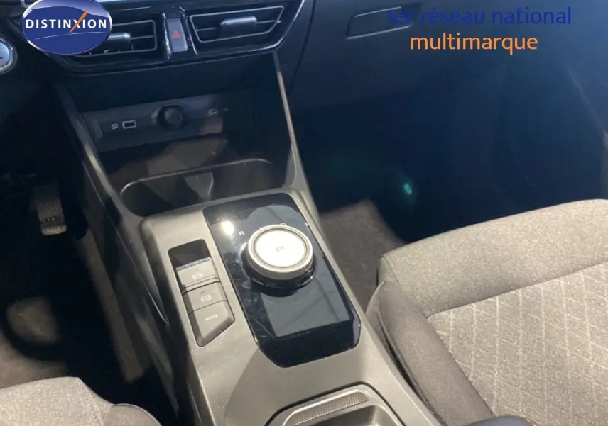 Vue rapprochée de la console centrale de la MG3 1.5 Hybrid 2024, avec boîte automatique et sellerie tissu gris.