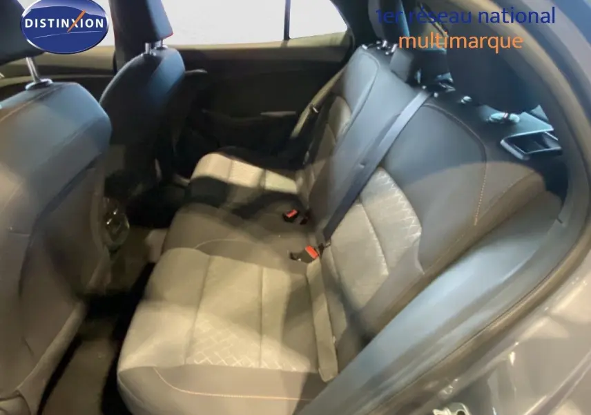 Vue intérieure arrière des sièges en tissu gris noir de la MG3 1.5 Hybrid 2024, avec ceinture de sécurité et porte ouverte.