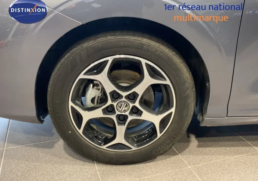 Gros plan sur la roue avant gauche de la MG3 1.5 Hybrid 195ch Comfort en gris Hampstead, avec jante alliage bicolore.