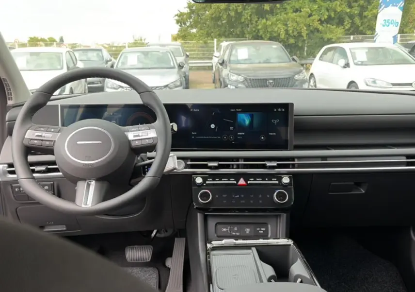 Vue intérieure avant du Hyundai Tucson 2026 gris shimmering, avec tableau de bord numérique et volant multifonction cuir.