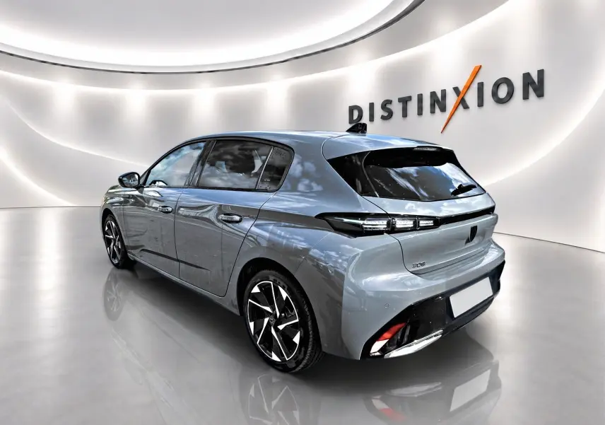 Peugeot 308 gris vue 3/4 arrière droit dans un showroom avec jantes alliage et feux LED distinctifs.