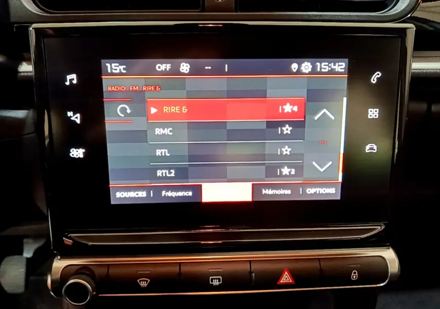 Écran tactile central affichant les stations radio dans l'habitacle d'une Citroën C3 beige de 2022.