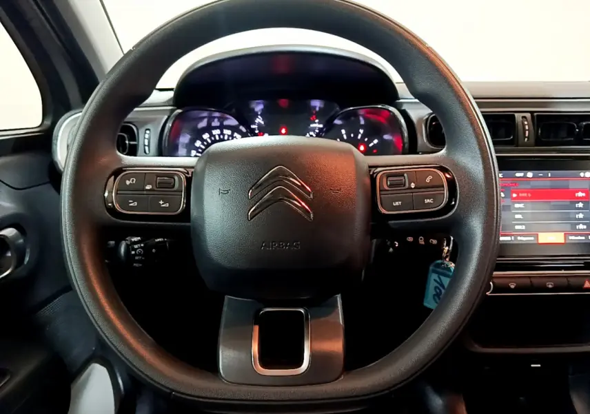 Vue centrée sur le volant noir de la Citroën C3 2022 avec tableau de bord et écran tactile visible à droite.
