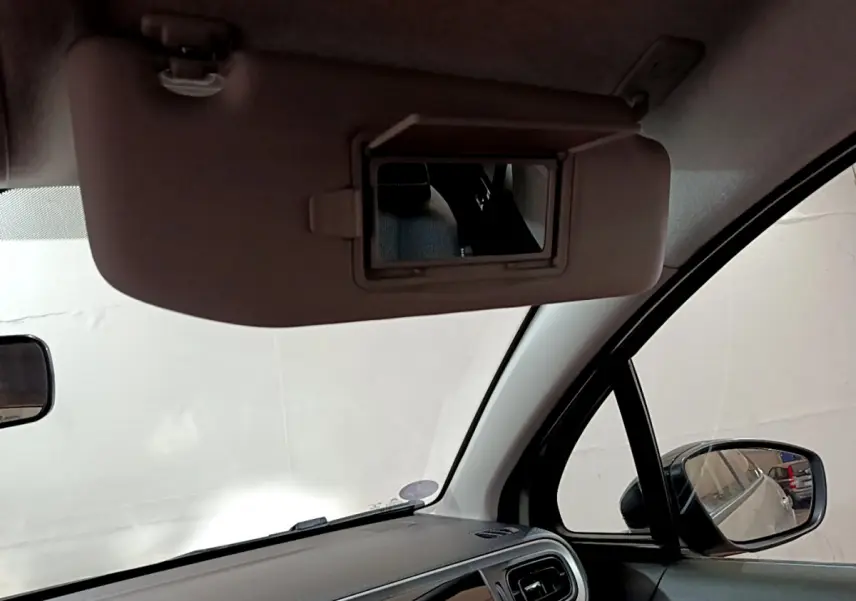 Miroir de courtoisie ouvert sur pare-soleil côté conducteur dans l'habitacle beige d'une Citroën C3 2022.