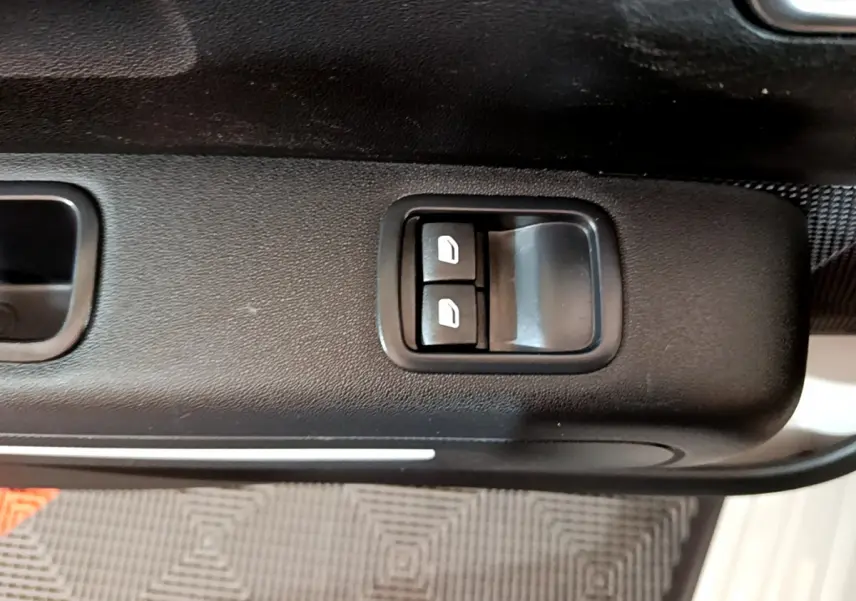 Gros plan sur les commandes de lève-vitres côté conducteur de la Citroën C3 beige 2022.