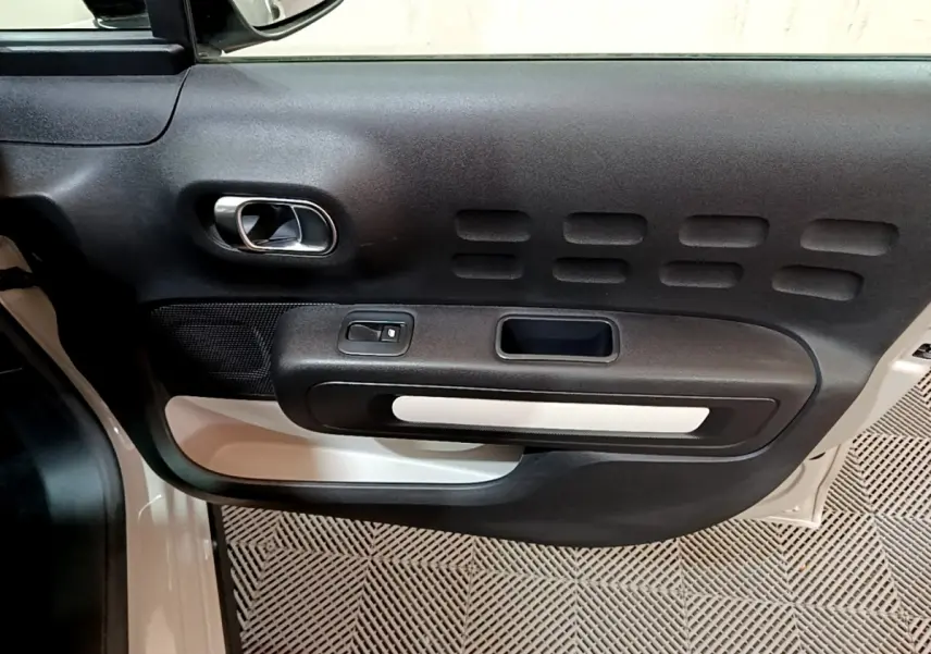 Vue rapprochée de la porte avant gauche beige de la Citroën C3 2022 avec poignée chromée et commandes électriques.