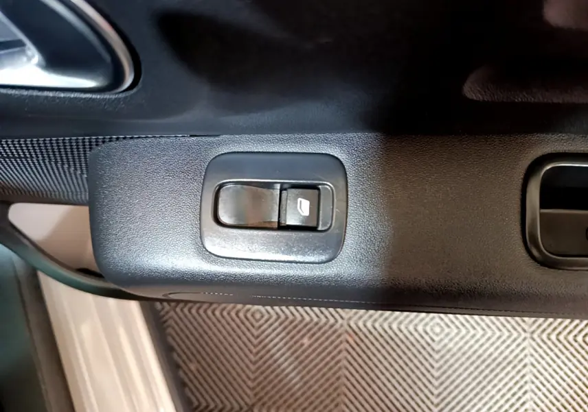 Bouton de commande de lève-vitre sur la portière côté conducteur d'une Citroën C3 beige 2022.