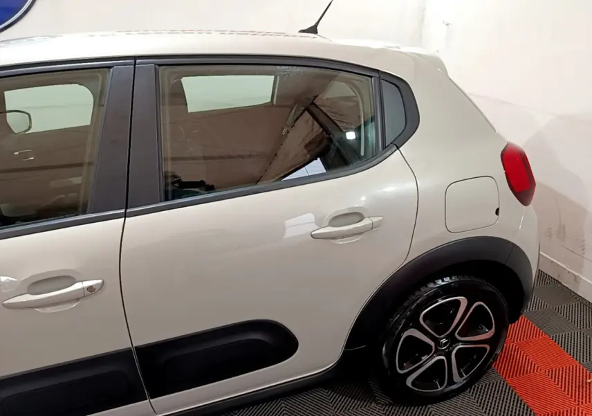 Vue latérale côté droit d'une Citroën C3 beige 2022 avec protections noires et jantes alliage distinctives.