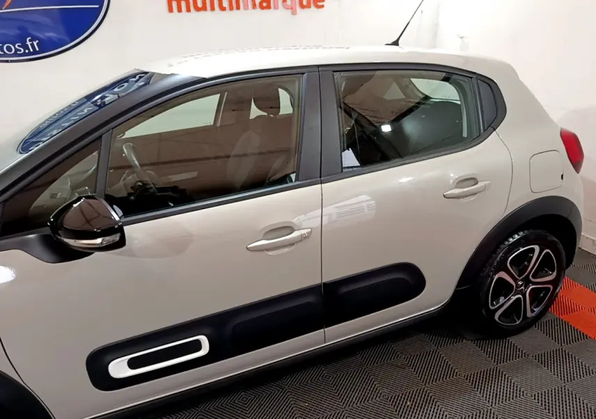 Vue latérale droite d'une Citroën C3 beige 2022 avec protections noires et jantes alliage distinctives.