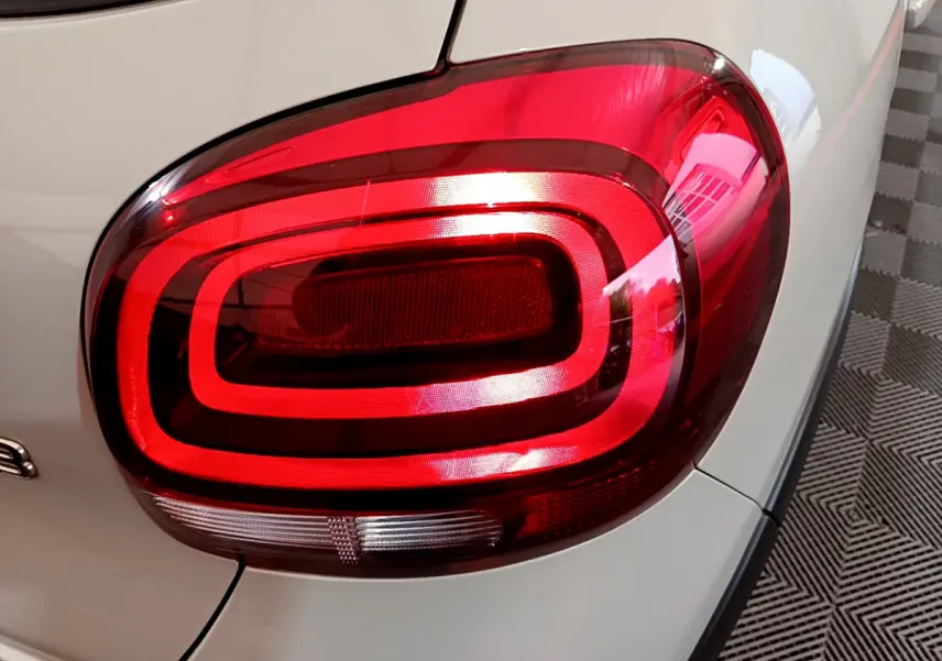 Gros plan sur le feu arrière droit rouge d'une Citroën C3 beige 2022, mettant en valeur son design lumineux distinctif.