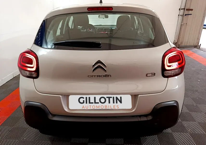 Vue arrière d'une Citroën C3 beige 2022 avec feux arrière LED allumés dans un garage.