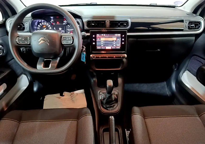 Vue intérieure avant de la Citroën C3 beige 2022, tableau de bord avec écran tactile et volant multifonctions.
