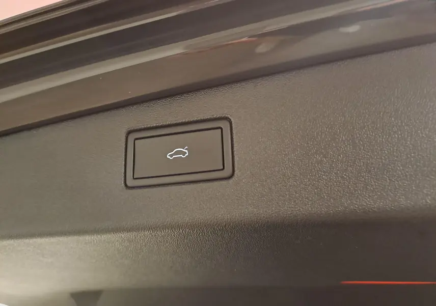 Bouton d'ouverture électrique du coffre sur le hayon intérieur d'un Volkswagen Tiguan gris Urano 2024.