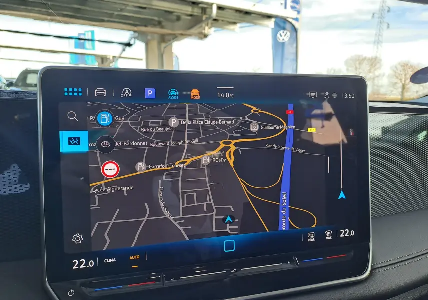 Vue intérieure du tableau de bord du Volkswagen Tiguan 2024 avec écran tactile affichant la navigation et la climatisation à 22°C.