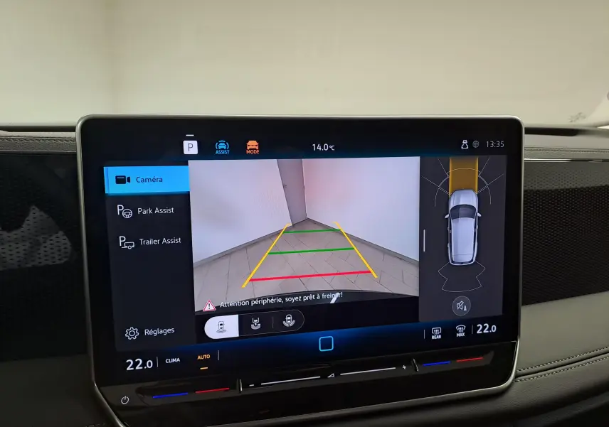 Vue de l'écran tactile du Volkswagen Tiguan 2024 gris Urano montrant l'assistant de stationnement avec remorque en marche.