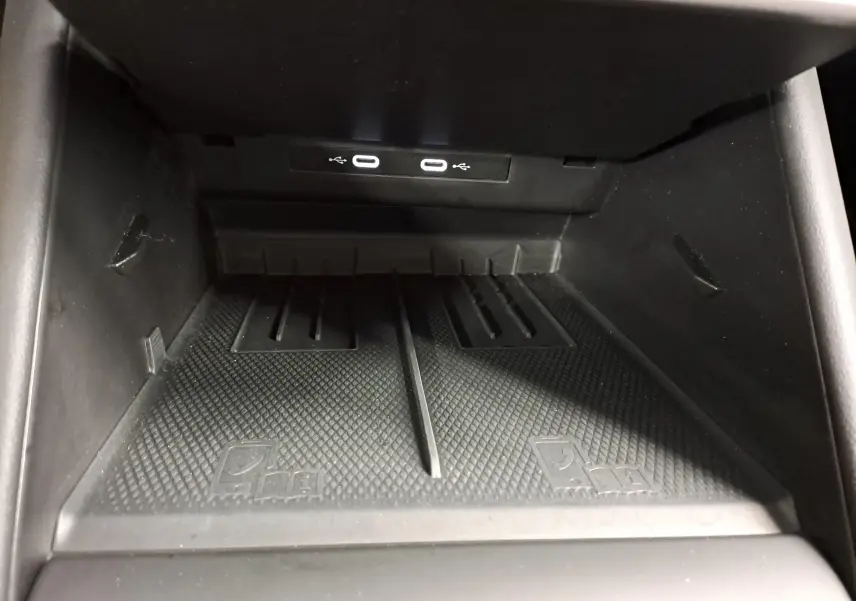 Gros plan sur la zone de chargement sans fil avec deux ports USB-C éclairés à l'avant d'un Volkswagen Tiguan Gris Urano 2024.