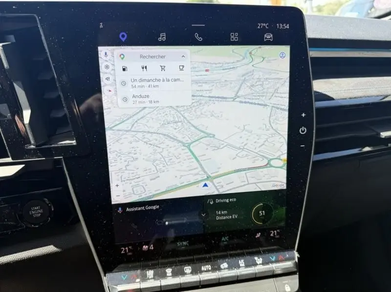 Vue intérieure centrée sur l'écran tactile du tableau de bord du Renault Austral rouge flamme, affichant la navigation GPS.